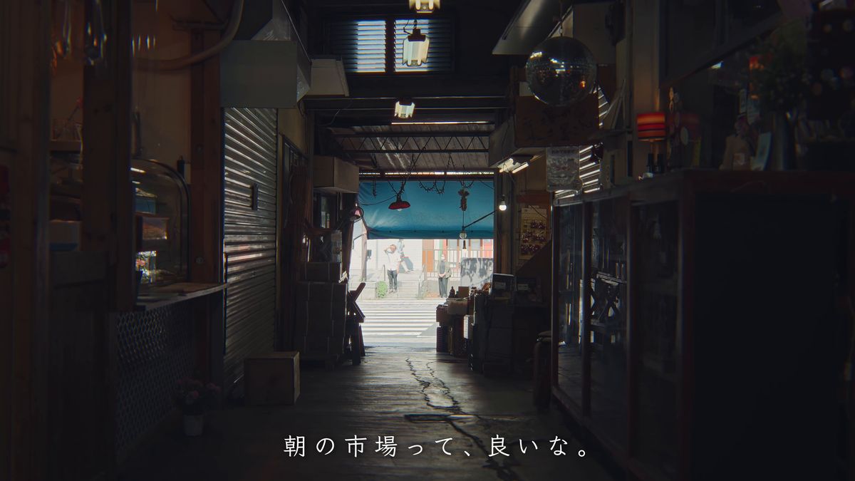 市場の暗い通路の先に見える明るい通り