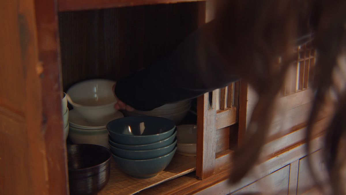 戸棚の器に手を伸ばす