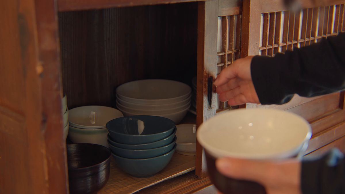 戸棚から白い碗を取り出す手元