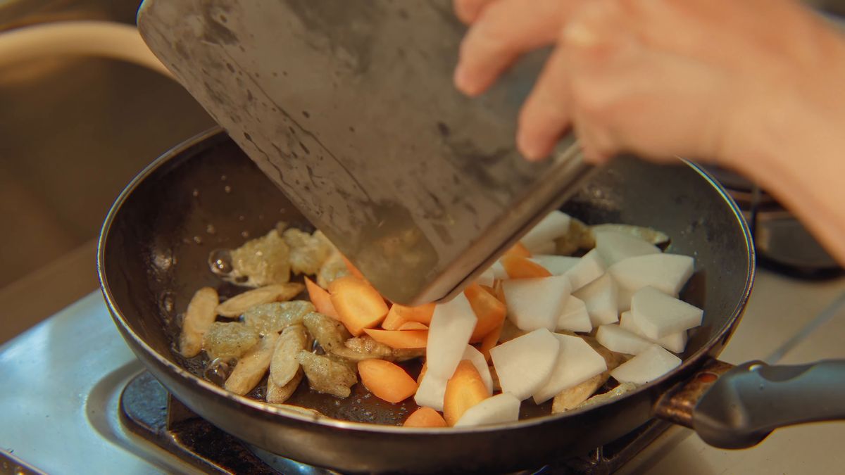 フライパンに野菜を入れる手元