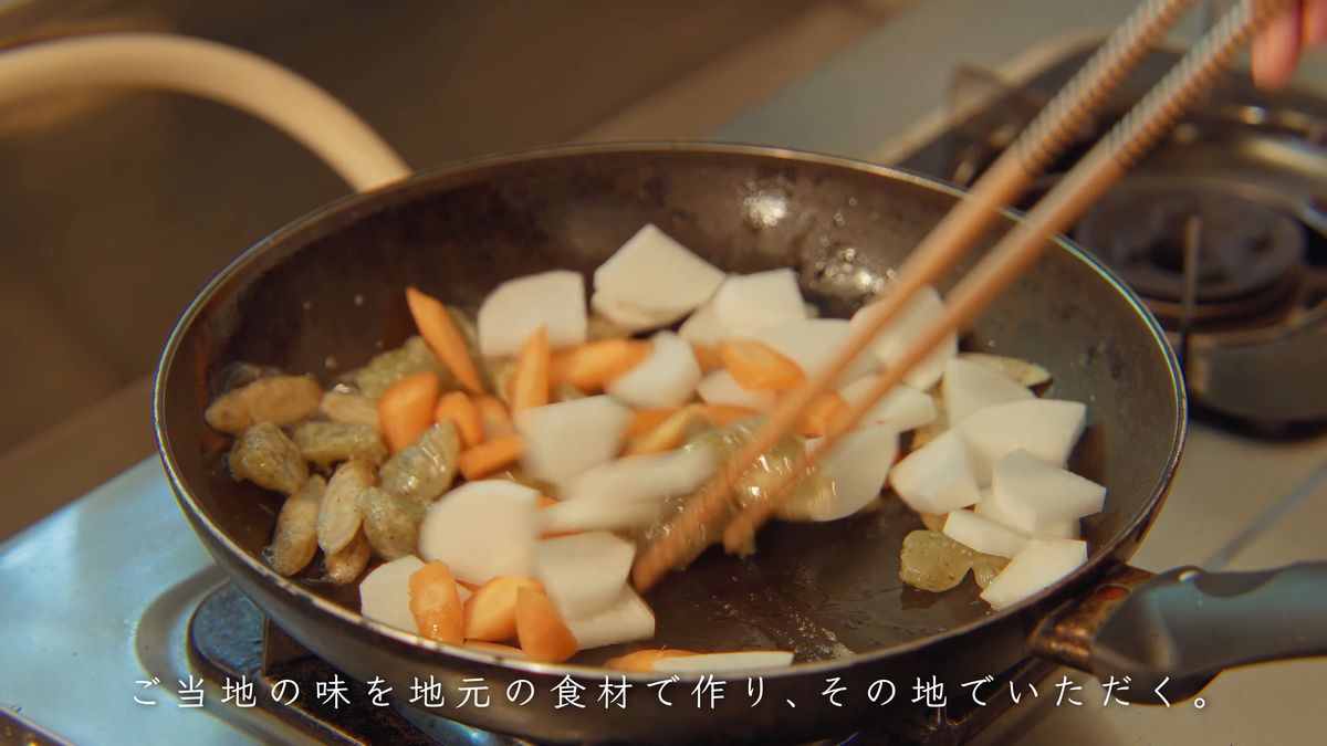菜箸で野菜を炒める手元