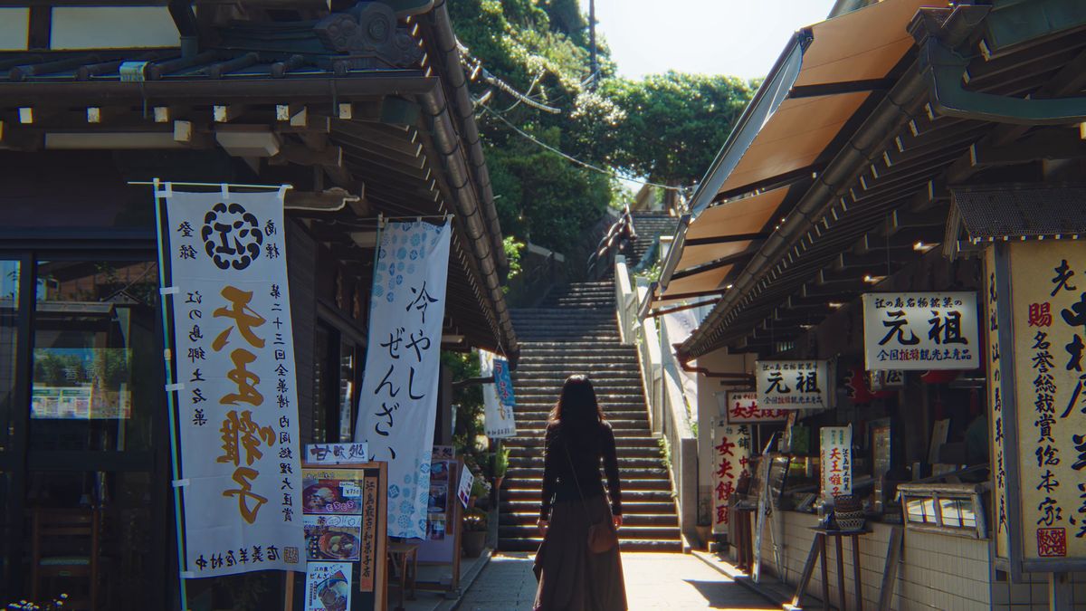 のぼりの立つ参道の石段を上る後ろ姿