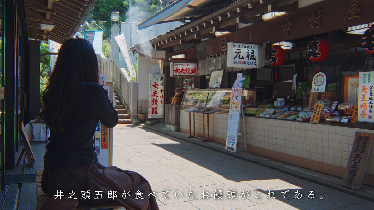 店の前のベンチに座る後ろ姿