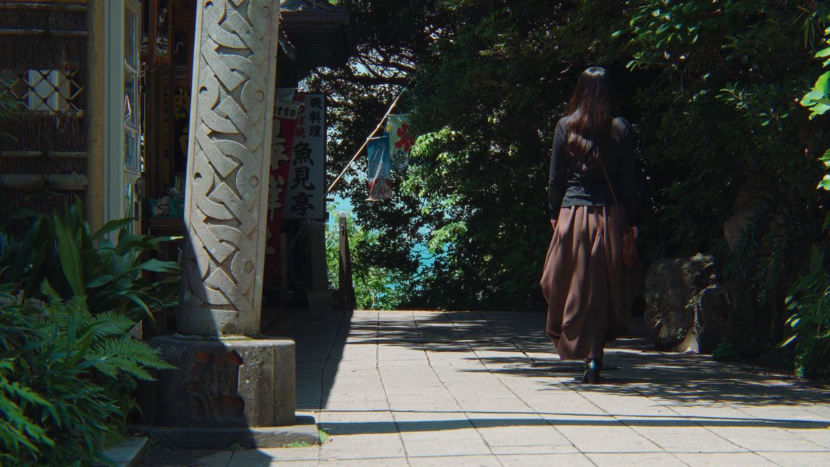 石碑の脇を歩く後ろ姿
