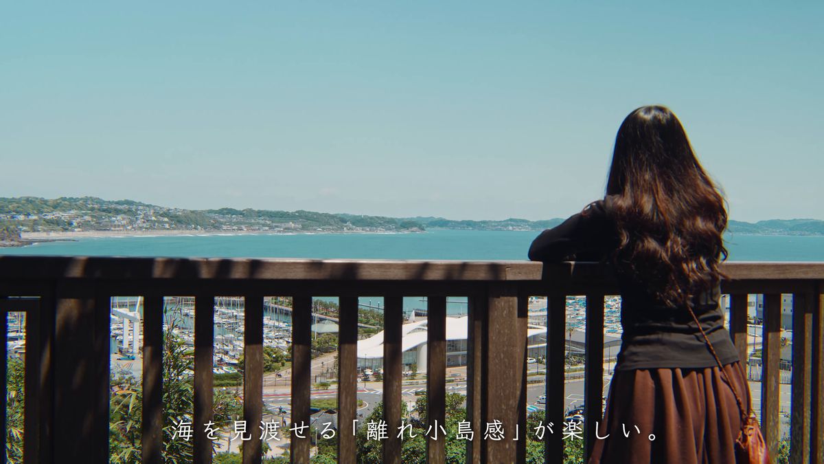 柵にもたれて海と対岸の町を眺める