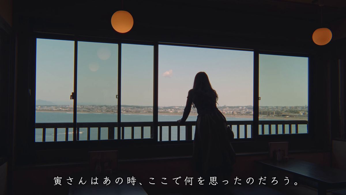 海を背に窓辺に立つシルエット