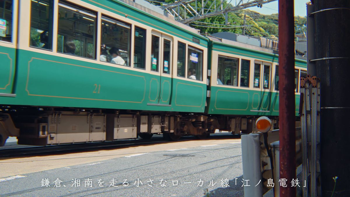 目の前を通り過ぎる緑とクリーム色の車両