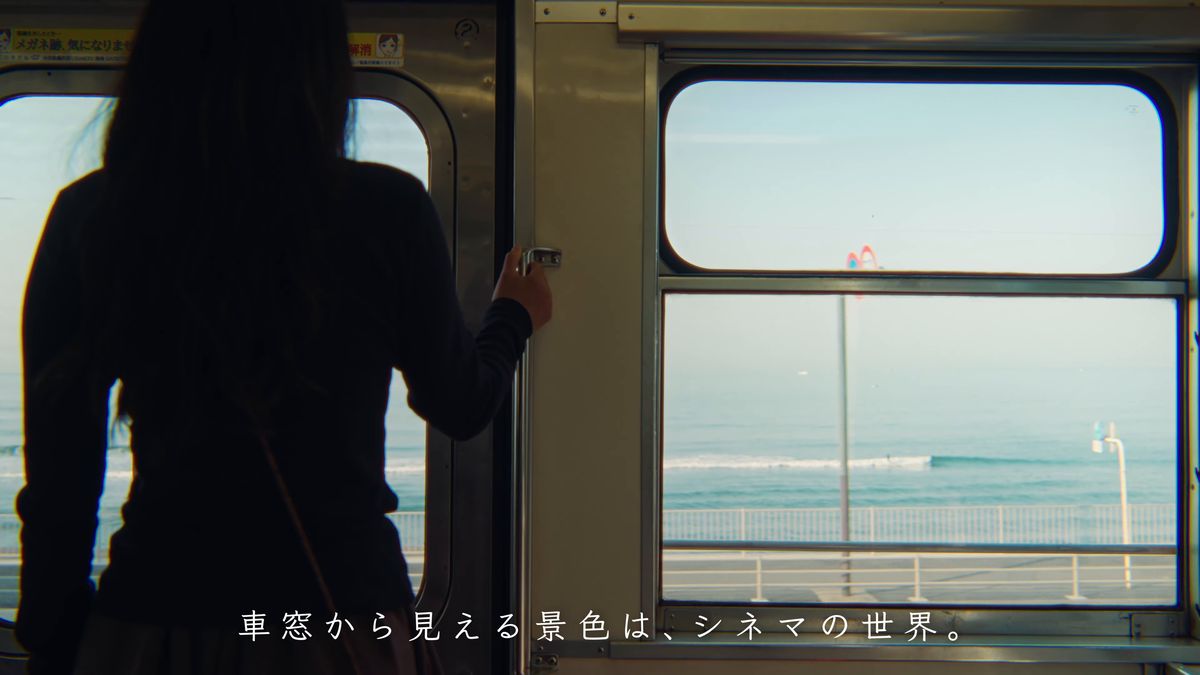 車窓いっぱいの海と、窓辺に立つ後ろ姿
