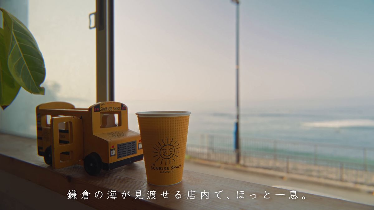 窓辺の紙コップと木のバスのおもちゃ、その向こうの海