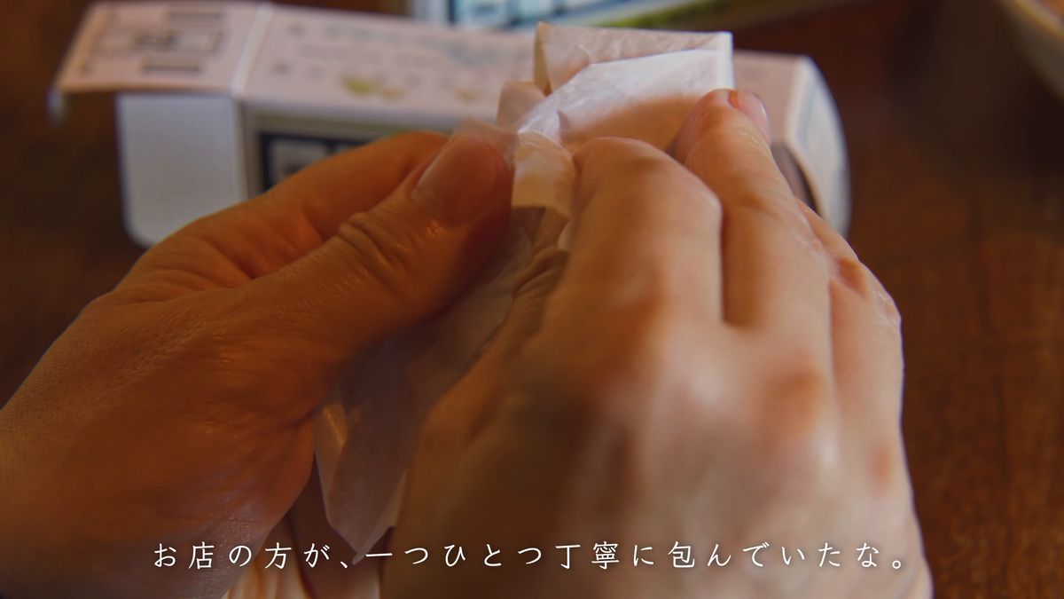 薄紙に包まれた最中をほどく手元