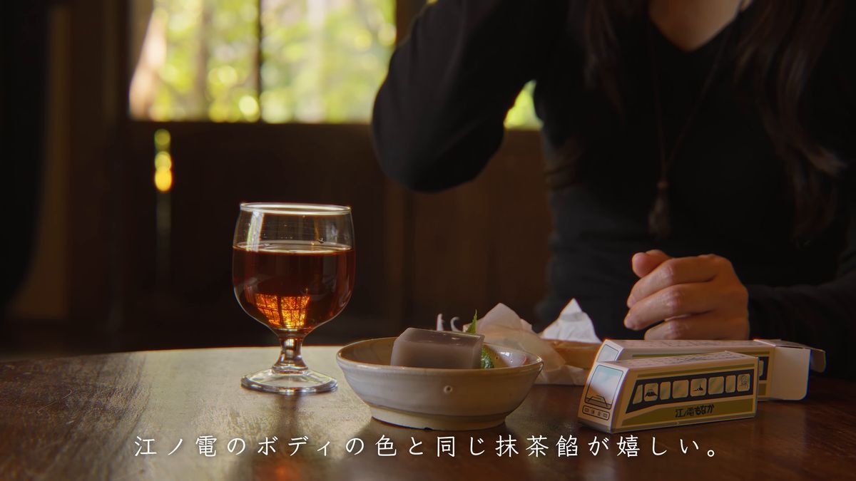 テーブルで最中を食べる手元と、グラスと箱