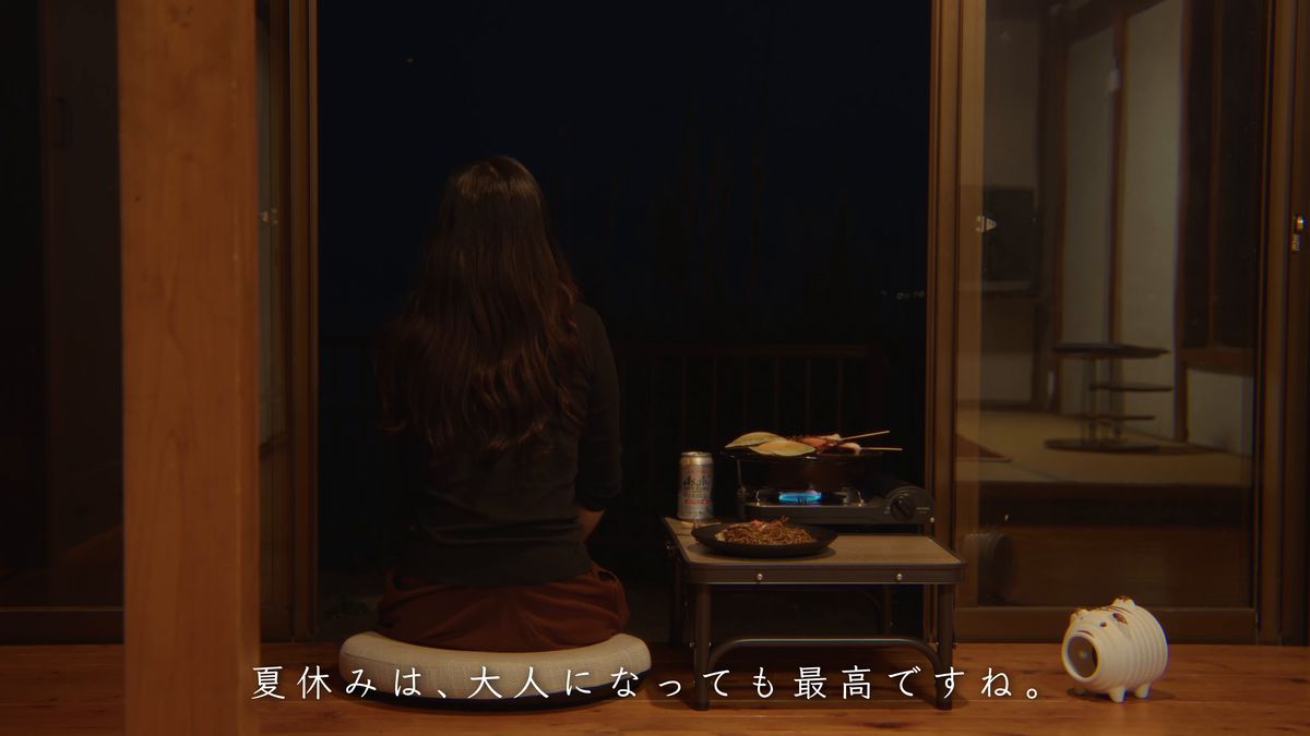 夜の縁側で食卓を前に座る後ろ姿