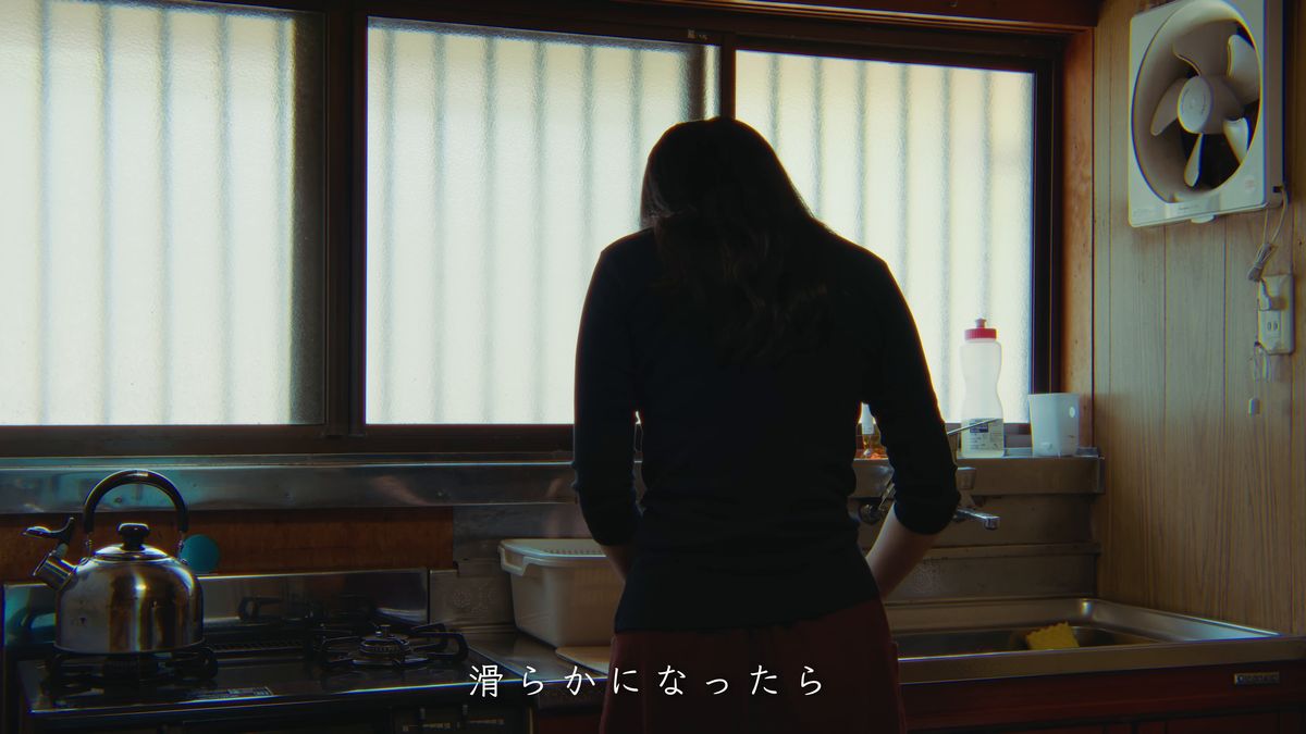 換気扇の回る台所に立つ後ろ姿