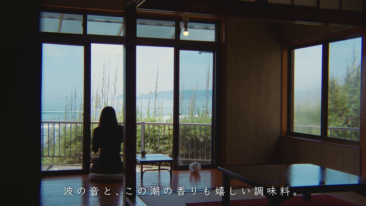 海に面した窓辺に座る後ろ姿