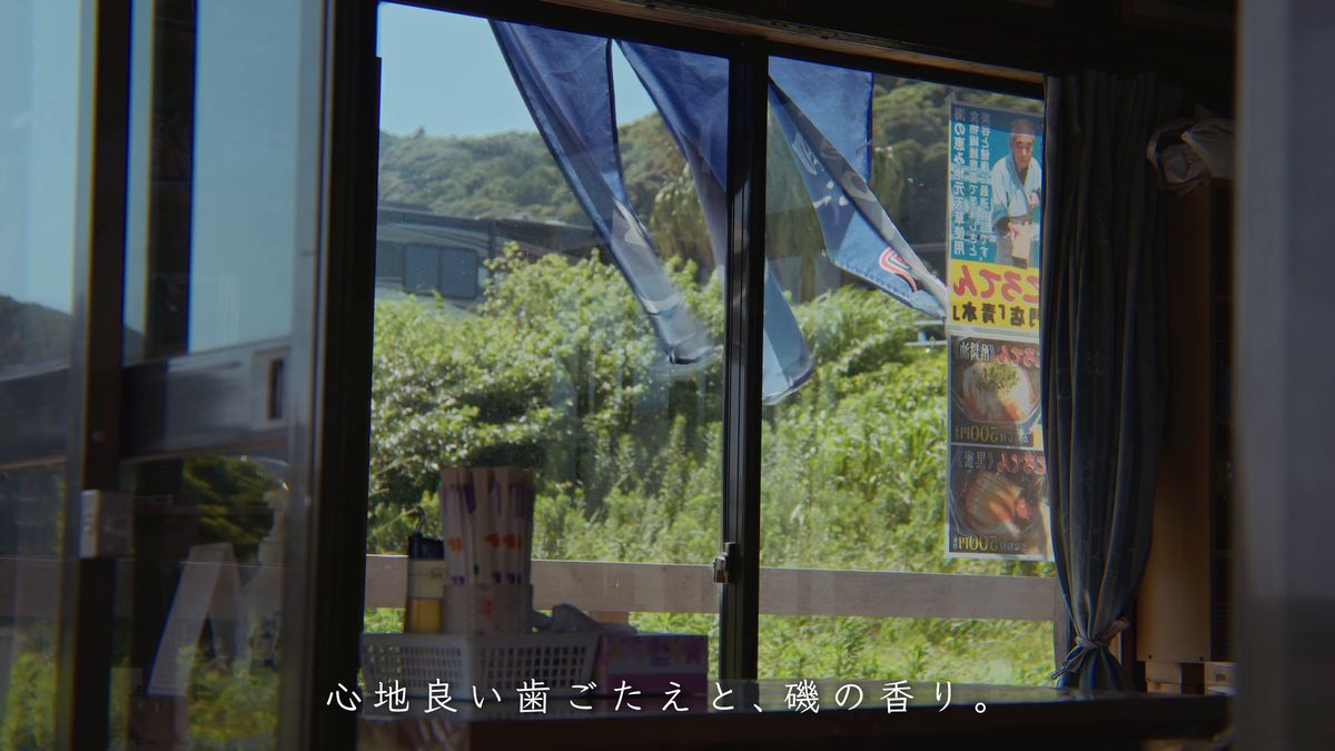 のれんの揺れる店の窓辺とポスター
