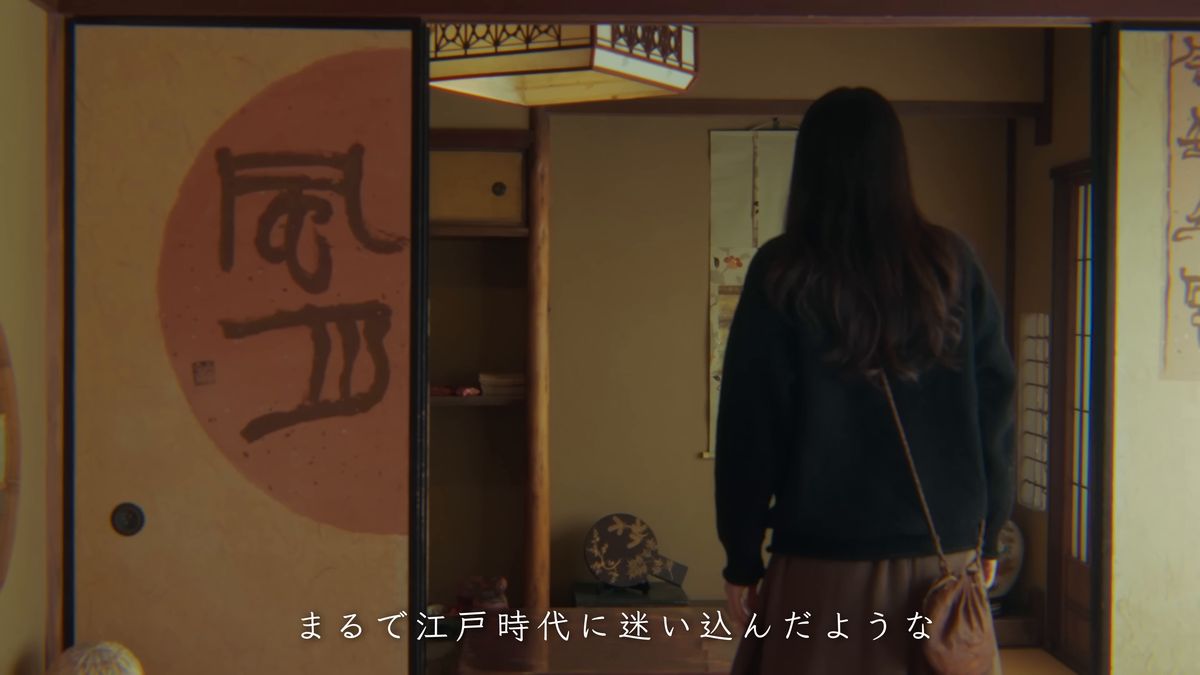 書の描かれた襖の座敷へ入る後ろ姿