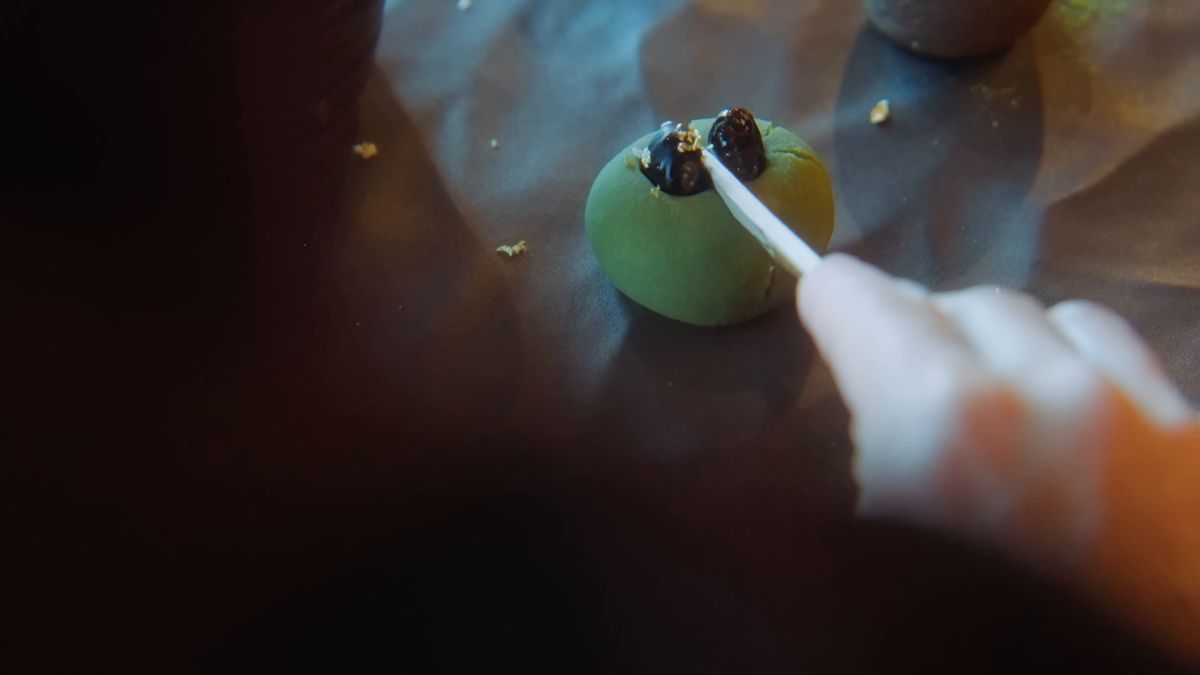 黒文字で緑の和菓子を切り分ける