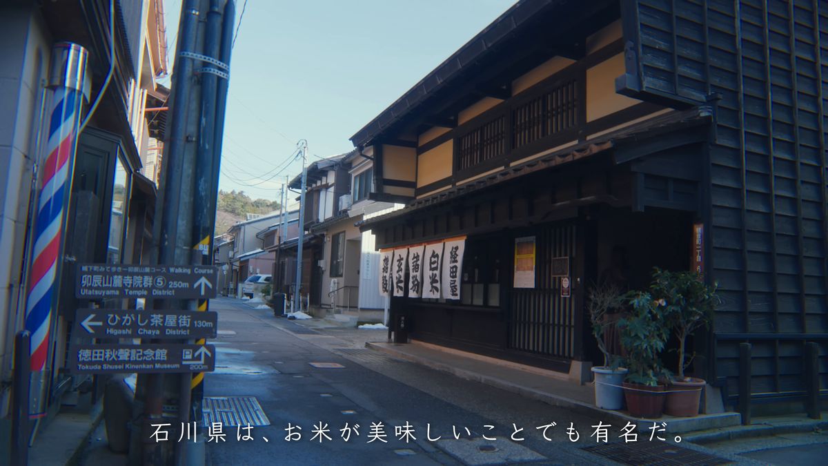 ひがし茶屋街への道しるべと、のれんの下がる米穀店