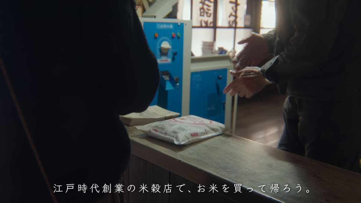 米穀店のカウンターで袋を受け取る
