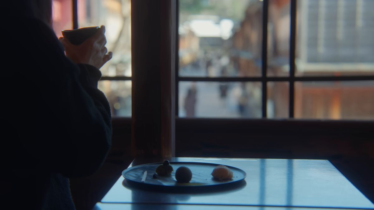 窓辺で茶碗を手にする