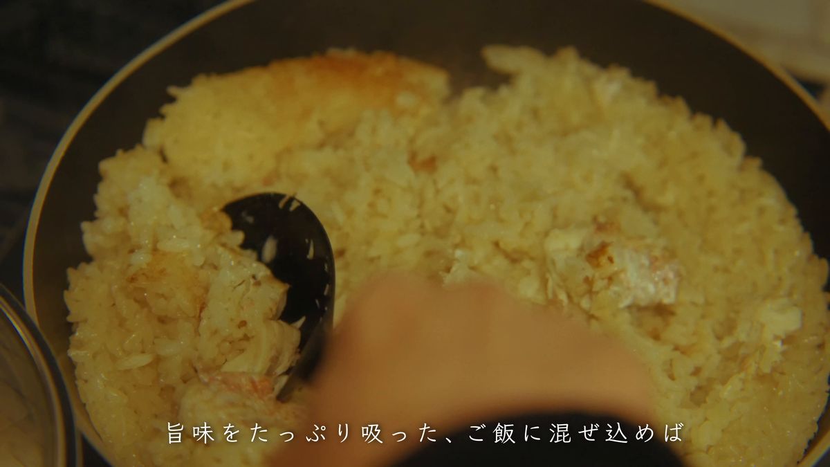 しゃもじでご飯と身を混ぜる