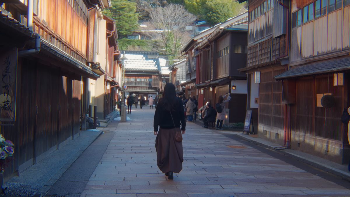茶屋が並ぶ石畳の通りを歩く後ろ姿