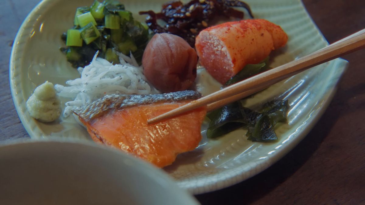 皿から鮭を箸で取る