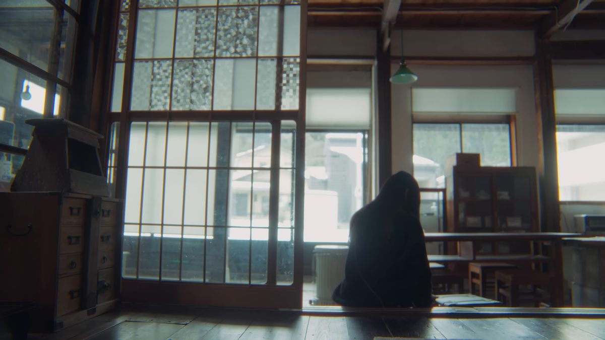 座敷のガラス戸の前で帰り支度をする