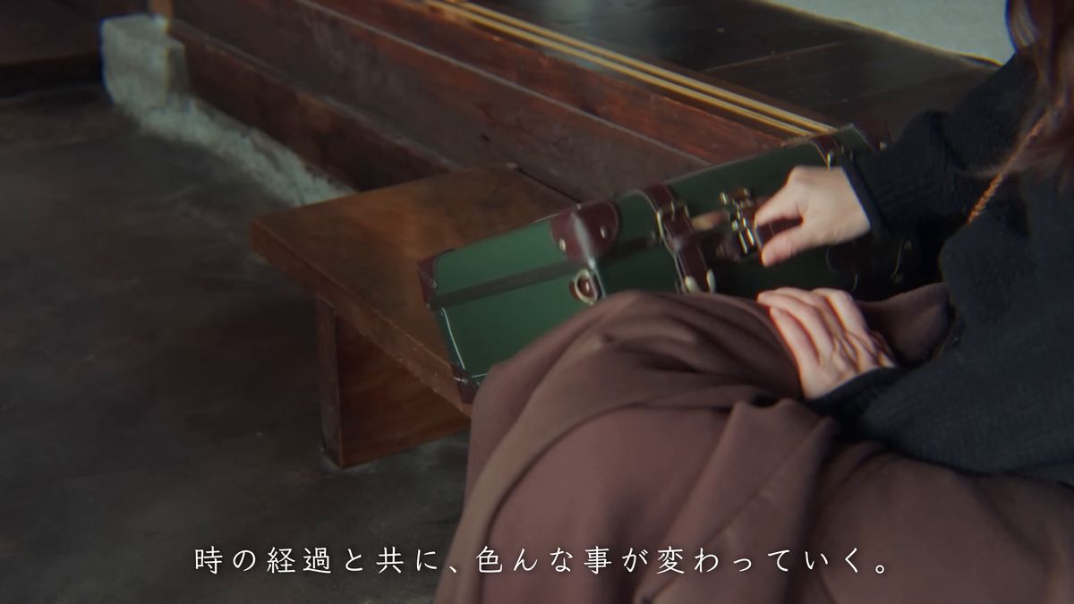 緑のトランクを閉める手元