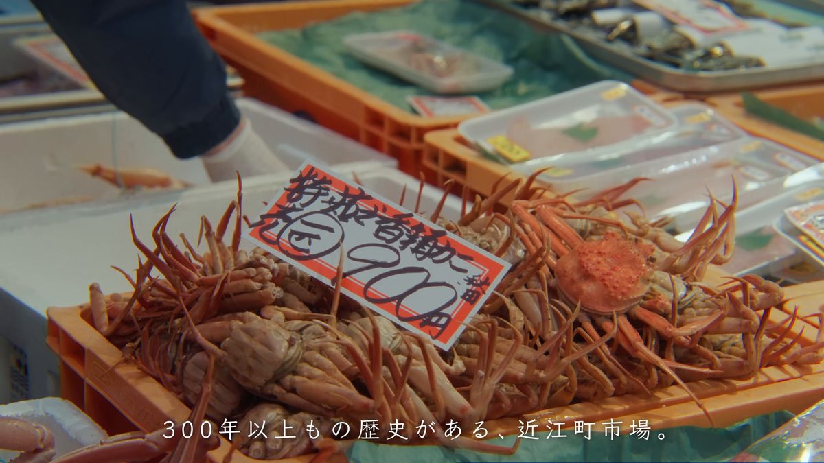 店頭に積まれたカニと手書きの値札
