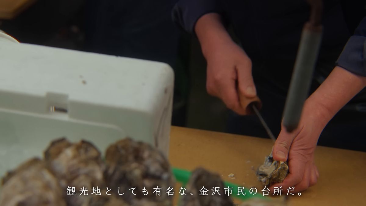 その場で牡蠣の殻を開ける手元