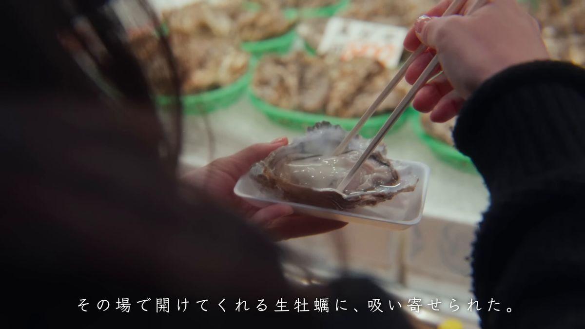 箸で生牡蠣を食べようとする手元