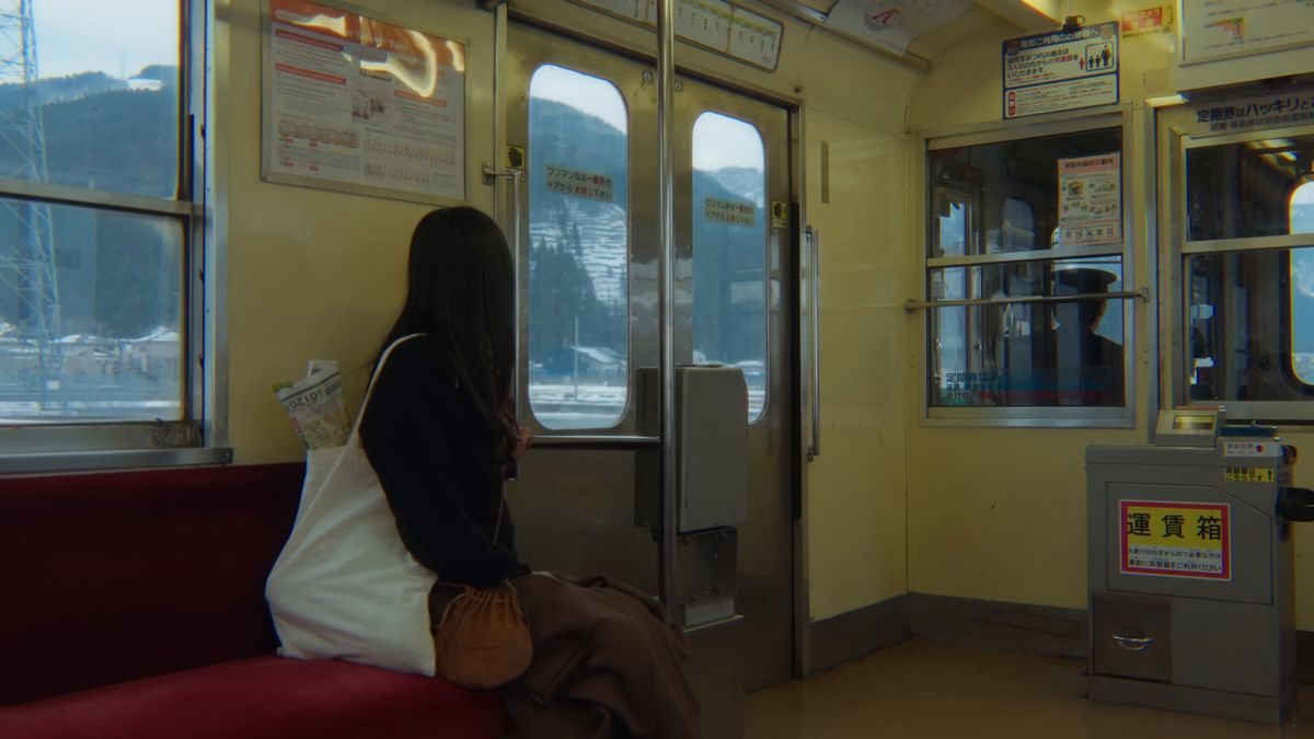 北陸鉄道の車内で、窓の外を眺める後ろ姿