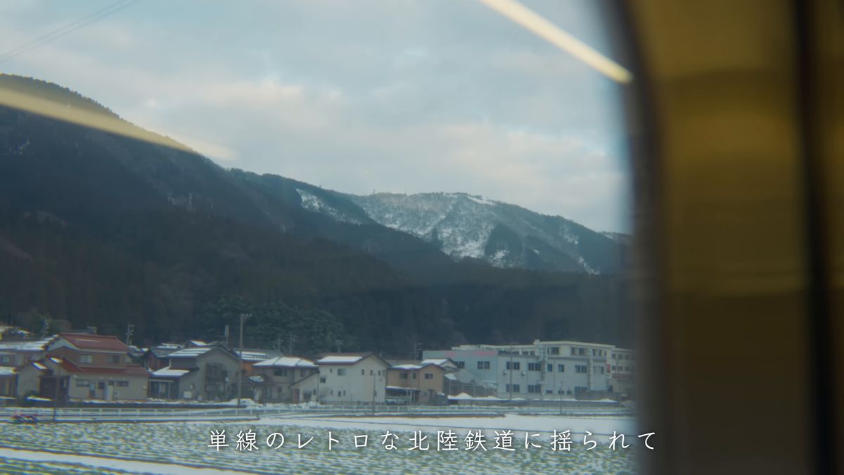 車窓に広がる雪の山と町並み
