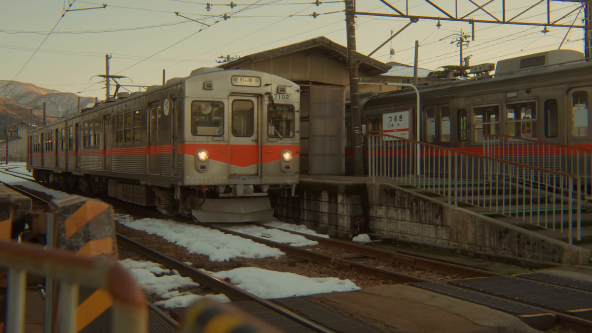 雪の線路と、夕日に照らされた電車
