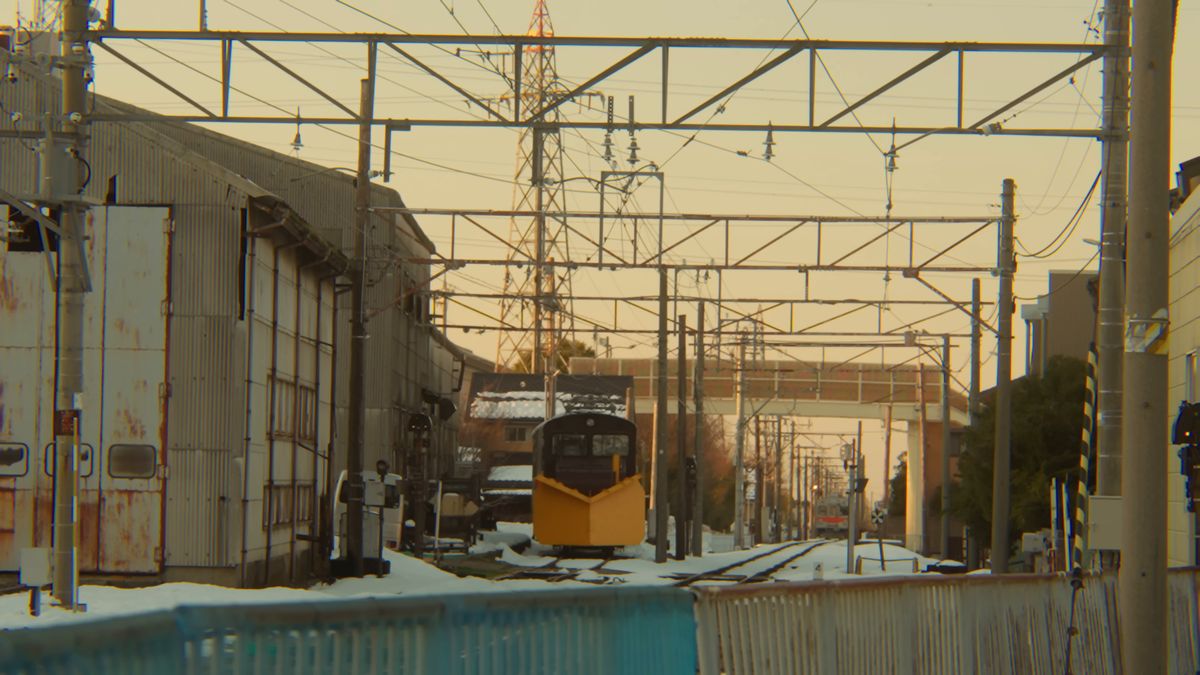 線路の先の車庫と黄色い車両