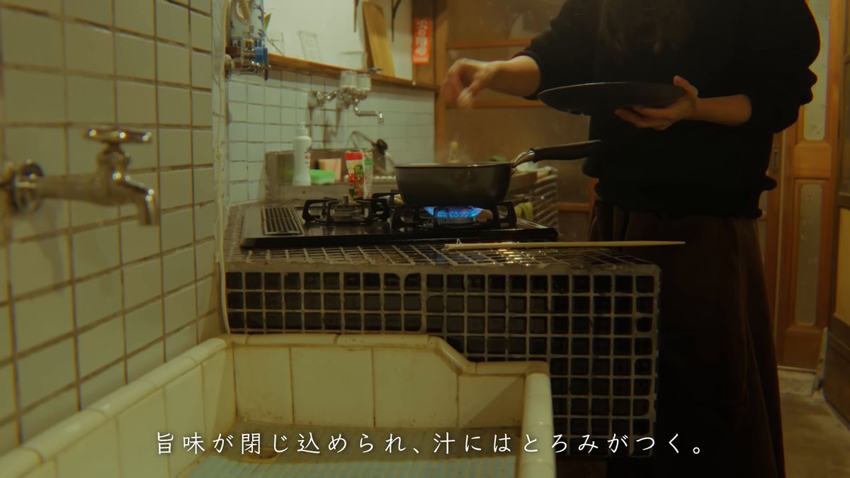 タイル張りの流しとガス台に立つ