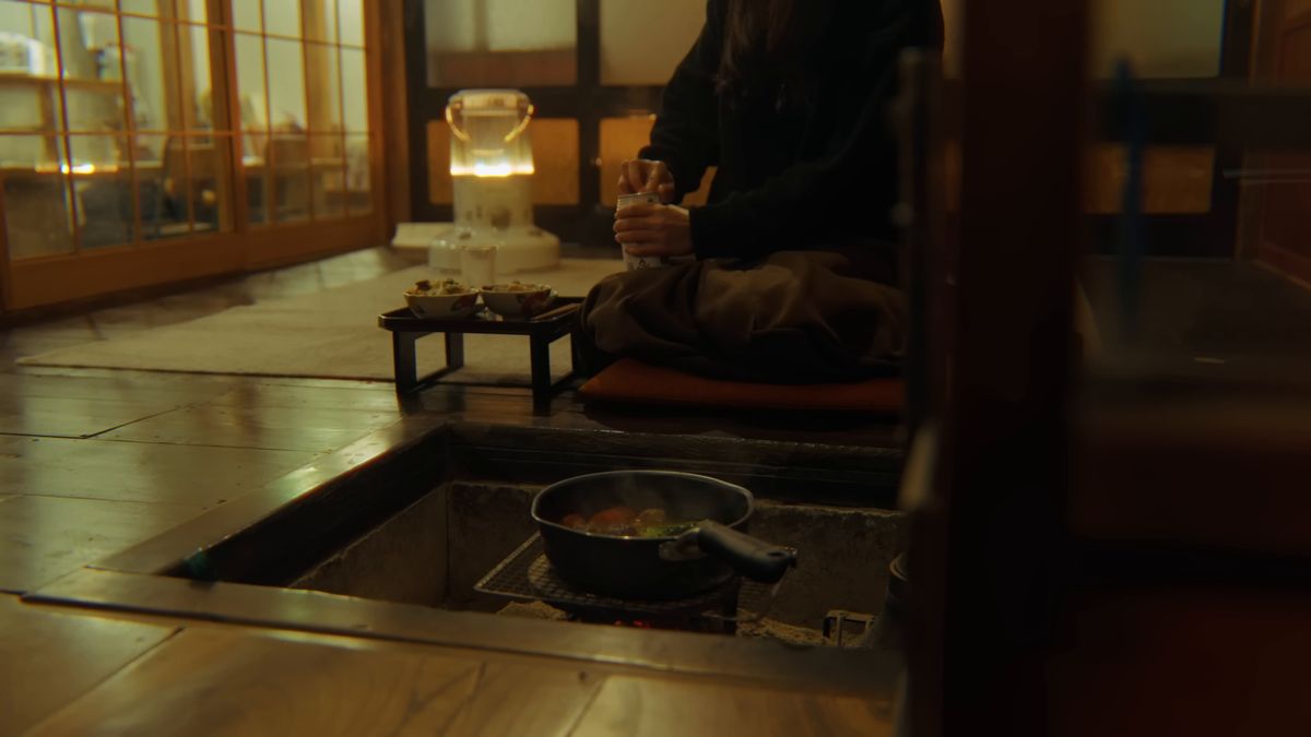 囲炉裏のある部屋で、膳の前に座る