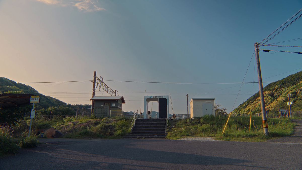 夕空の下の田並駅前のバス停と駅舎
