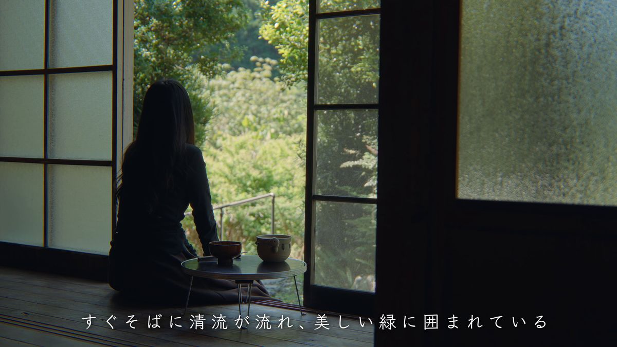 窓辺の卓で茶漬けを食べる後ろ姿