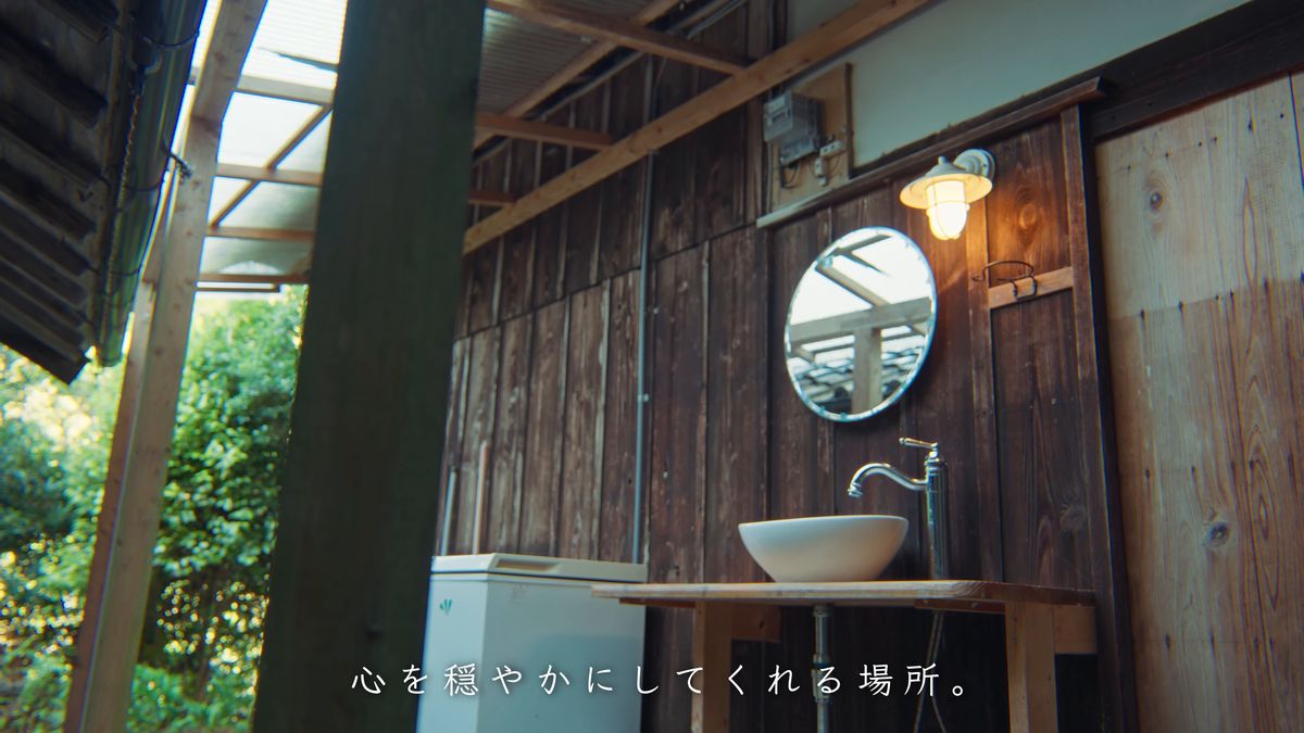 板壁の洗面台と丸い鏡