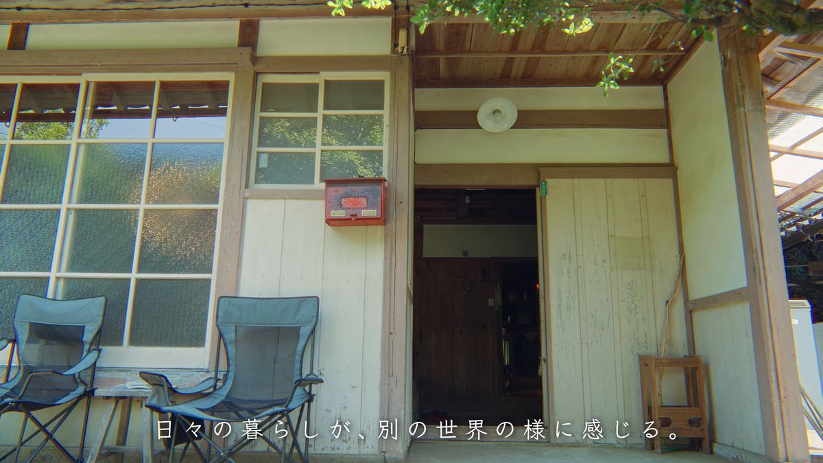 折りたたみ椅子と赤い郵便受けのある玄関