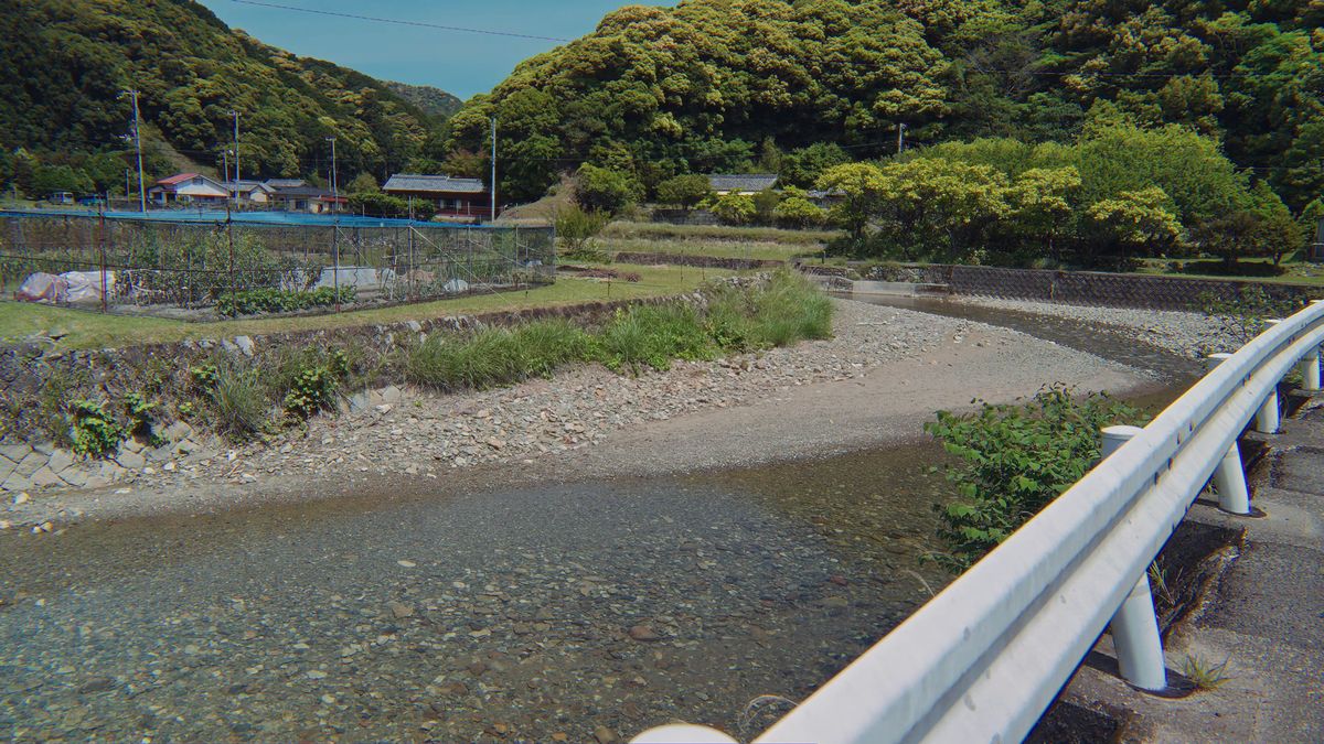 ガードレール越しの川と集落