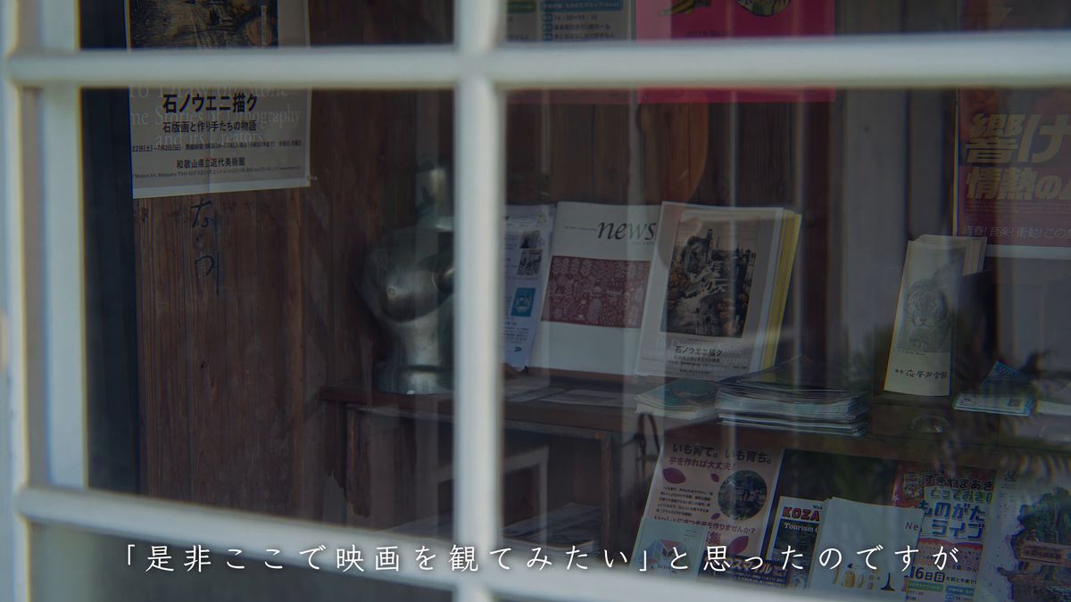 窓越しに見える美術展のポスターと冊子