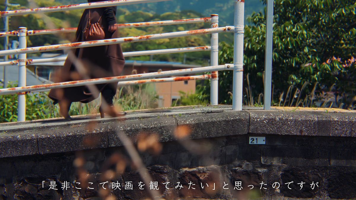 錆びた欄干の橋を歩く後ろ姿