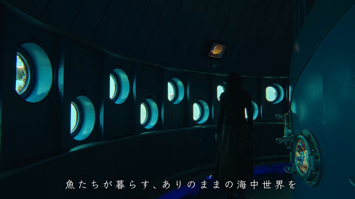 丸窓の並ぶ展望塔の中に立つ後ろ姿