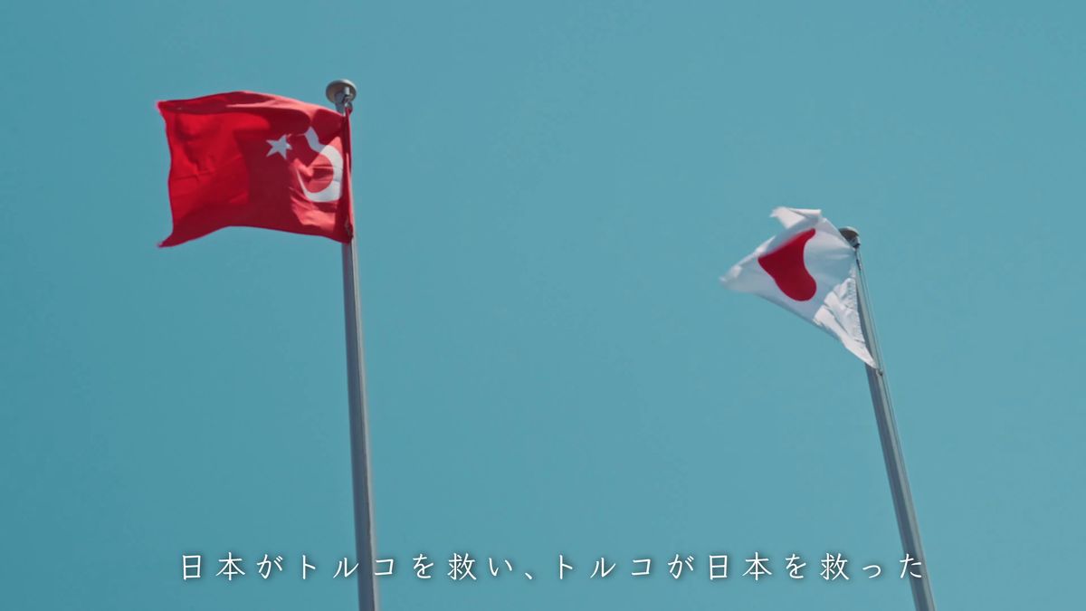 青空に並んで翻るトルコと日本の国旗