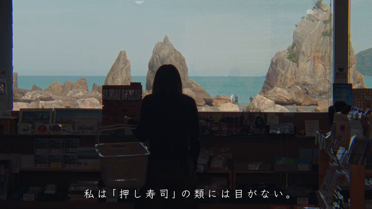 店の窓越しに橋杭岩を眺める後ろ姿