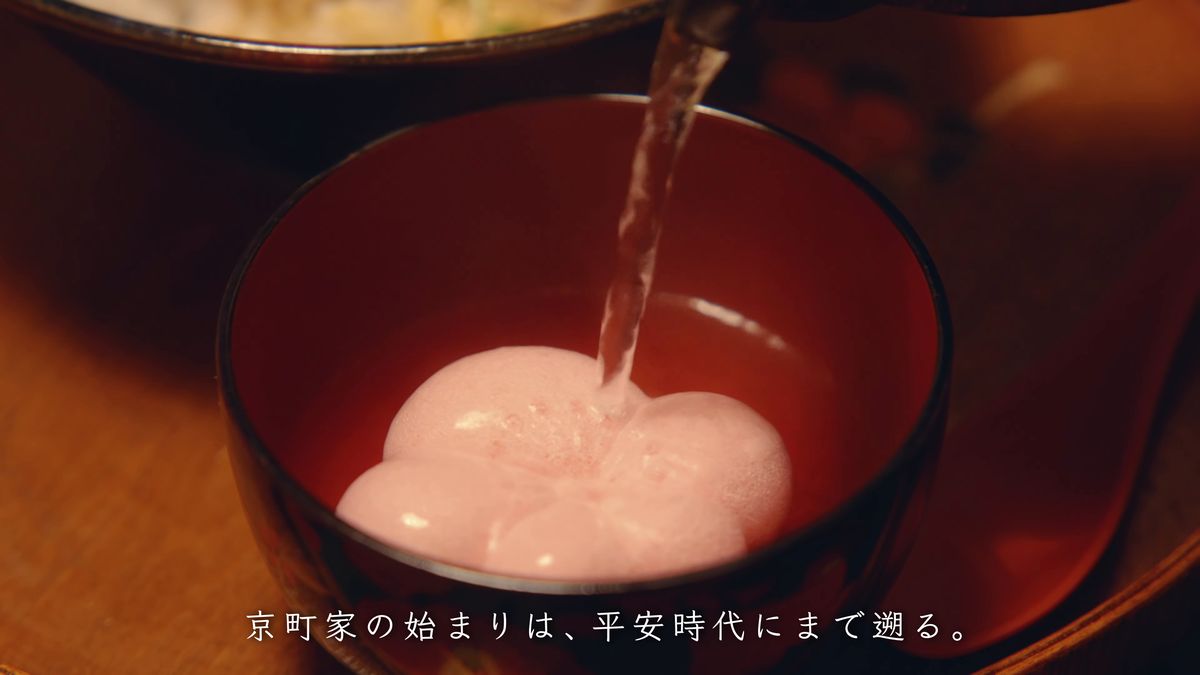 赤い椀の桃色の花麩に湯を注ぐ