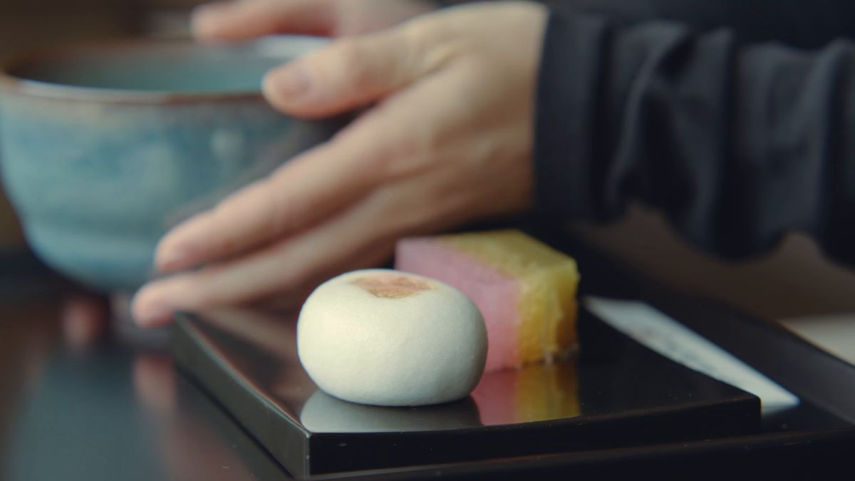 茶碗を置く手元と、盆の上の菓子